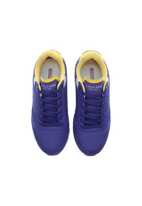 Fialové tenisky s texturovaným povrchem, žluté akcenty na límci a jazyku a kontrastním šedým brandingem. Standardní šněrovací design.