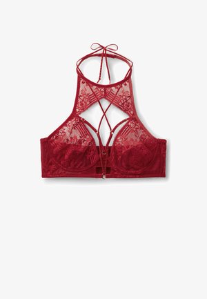 Bralette en dentelle rouge avec un design croisé dans le dos, des bretelles réglables, des bonnets avec armatures doublés et une fermeture à crochet et œillet.
