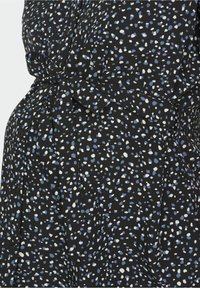 Robe noire avec un motif moucheté en bleu et blanc. Fabriquée en tissu doux avec une ceinture à la taille et des détails à boutons.