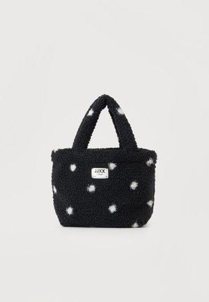 Sac fourre-tout en polaire noire à pois blancs, anses courtes et petite étiquette rectangulaire avec logo sur le devant.