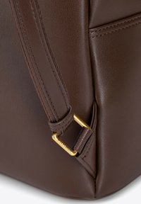 Borsa a tracolla in pelle marrone con superficie testurizzata, accessori in oro e una tracolla dettagliata con cuciture visibili.