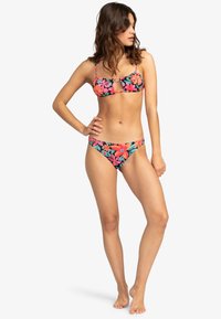Floral print bikini set met een zwarte achtergrond, felroze en oranje bloemen, met een uitsparing detail bij de bandeau top en bijpassende onderkant.