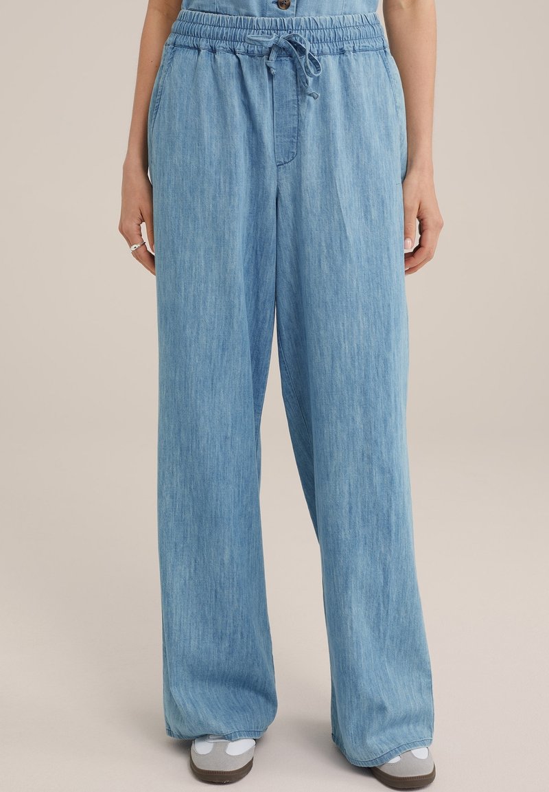 Ljusblå vida byxor i ett mjukt, denimliknande tyg med elastisk midja och dragsko, som har en avslappnad och flödande silhuett.