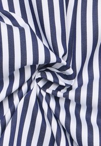 Baumwollstoff mit wechselnden Marineblauen und weißen Streifen. Das Material ist strukturiert und zeigt ein weiches, gewebtes Design mit einem leichten Glanz.
