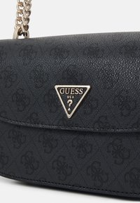 Borsa nera con texture, caratterizzata da una placca logotipo dorata a forma triangolare e una tracolla a catena. Presenta una superficie decorata e una chiusura a pattina.