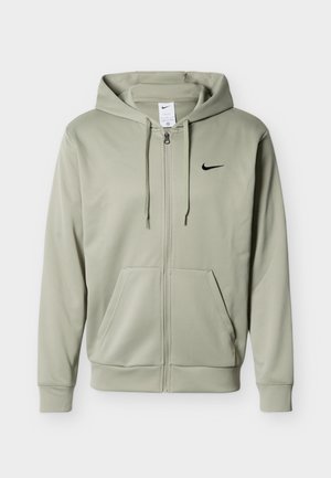 Helehall zip-up kapuutsiga dressipluus ees taskute, tõmbelintidega kapuutsil ja väikese musta Nike logoga vasakul rinnal.