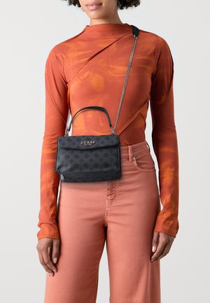 Borsa nera con motivo a rilievo e chiusura a patta magnetica, indossata a tracolla con catena argentata, con logo dorato sul davanti.