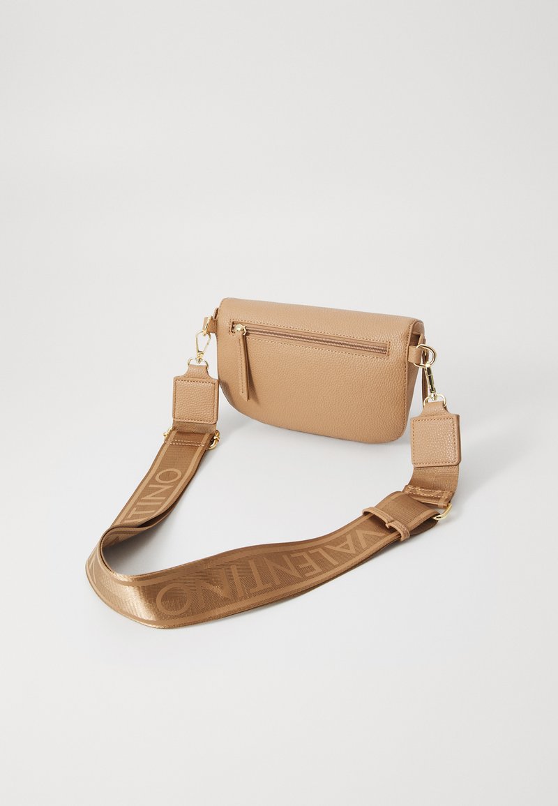 Bolso de cuero color marrón claro con forma rectangular, que cuenta con un bolsillo con cremallera y una amplia correa de tela adornada con el logotipo "Valentino".