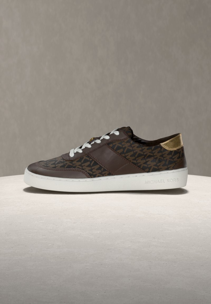 Rjav patinasti čevelj z belimi vezalkami, usnjenim zgornjim delom, zlatim poudarkom na peti in belo gumijasto podplato. Oznaka "MICHAEL KORS."