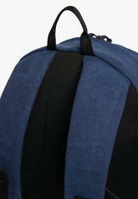 Niebieski plecak z teksturowanej tkaniny, czarnymi siateczkowymi akcentami na paskach, wzmocnionym uchwytem u góry oraz detalami zamka błyskawicznego.