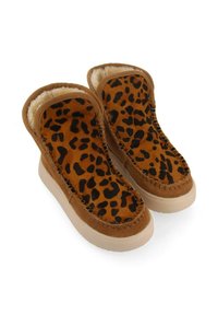 Zapatos de ante marrón tipo slip-on con estampado de leopardo, forro suave y suela texturizada; cuenta con detalles de costura y un diseño redondeado.