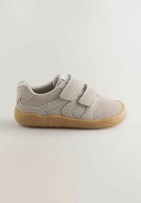 Baskets pour tout-petit en daim beige clair avec deux bandes Velcro et une semelle en caoutchouc épaisse de couleur tan sur un fond uni.