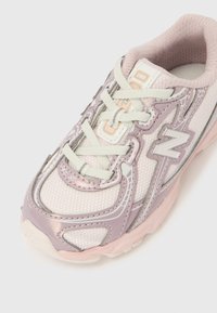 Világos rózsaszín és levendulaszínű sportcipő hálós anyaggal, fehér fűzőkkel és oldalt látható "N" logóval, felülről és elölről nézve.