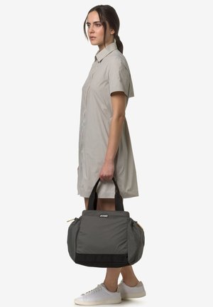 Borsa in tessuto grigio con fondo nero e cerniere gialle, dotata di due manici. La borsa ha una finitura morbida e strutturata con una forma definita.