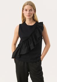 Black sleeveless top with a ruffled accent on one side, made from smooth fabric. The design features a crew neckline and relaxed fit.