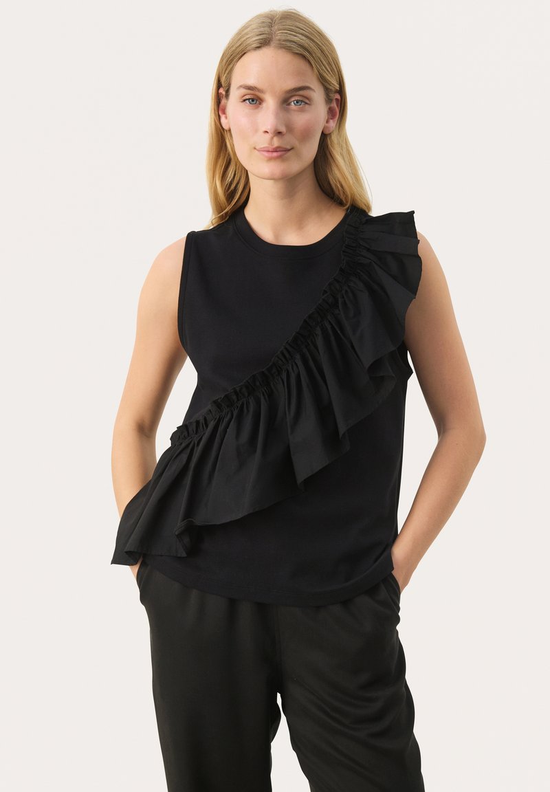 Black sleeveless top with a ruffled accent on one side, made from smooth fabric. The design features a crew neckline and relaxed fit.