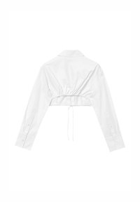 Camicia bianca cropped con maniche lunghe, colletto e una coulisse regolabile sul retro per un look aderente. Tessuto morbido.