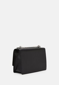 Musta suorakulmainen käsilaukku, jossa on sileä pinta ja hopeinen ketjukahva, valkoista taustaa vasten, hieman vinossa vasemmalle.