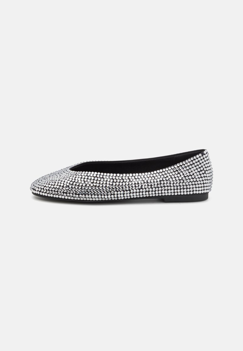 Platte schoenen bedekt met zilveren rhinestones, met een ronde neus en een lage zwarte zool, met een gladde stoffen binnenkant.