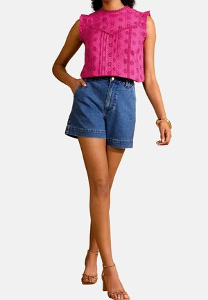 Fuchsia embroidered sleeveless top with ruffled shoulders, paired with denim shorts. The shorts have a relaxed fit and rolled hem.