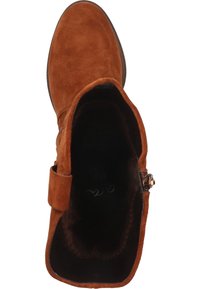 Botín de ante en rico color marrón, con textura aterciopelada, forro suave y una correa con hebilla decorativa. Punta redondeada y suela resistente.