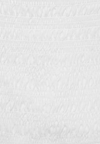 Tissu blanc avec smocks texturés, présentant des ondulations horizontales et des rangées froncées, créant une apparence douce et superposée.