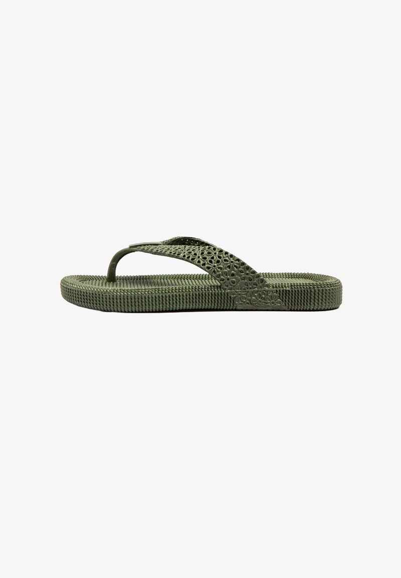 Chancla verde con suela de goma texturizada y diseño decorativo de recortes en las correas. Diseño ligero y flexible para mayor comodidad.