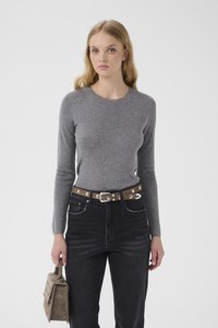 Grå langermet skjorte med høy hals, kombinert med høye, svarte jeans og et brunt belte med sølvnagler. Holder en taupe-farget håndveske.