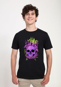 Černé tričko s živou grafikou purpurové lebky obklopené barevným graffiti-style textem a akcenty v zelené a růžové.