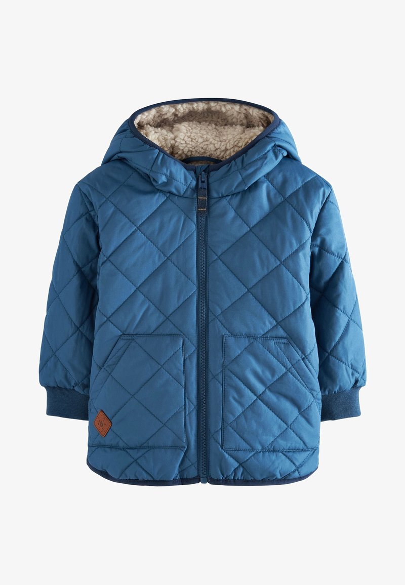 Veste matelassée bleue avec une capuche, dotée d'une douillette doublure beige, de deux poches avant et de poignets côtelés. Fermeture éclair à l'avant.