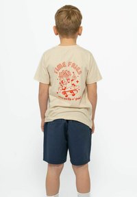 Camiseta de algodón beige de manga corta con un gráfico rojo de papas fritas en un patinete y el texto "TIME FRIES" en la parte posterior.