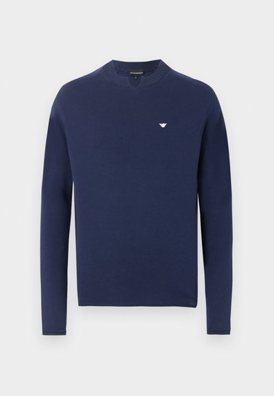 Μπλε ναυτικό πουλόβερ με μακριά μανίκια και στρογγυλή λαιμόκοψη, με ριμπ μανσέτες και μικρό λευκό λογότυπο αετού στο αριστερό στήθος.