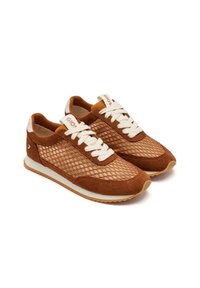 Zapatillas de ante marrón con parte superior de malla, cordones blancos y suela de goma texturizada. Presentan un acento crema en el talón y la lengua.