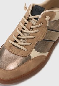 Brun sportssko med metallic bronze og creme detaljer, tekstureret læder og stofsnørebånd i et klassisk design med gummisål.