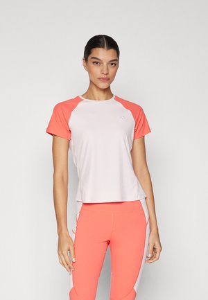 Lys rosa treningstrøye med korallfargede raglanermer, laget av strukturert stoff, med en liten logo på brystet. Kombinert med korallfargede leggings.