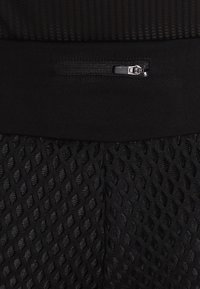 Svarta träningsbyxor med en strukturerad diamantmönster, med en slät midja och en liten dragkedjeficka på sidan.