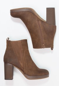 Brązowe ankletowe botki z sztucznego zamszu, z kwadratowym noskiem, bocznym zamkiem błyskawicznym, elastycznymi panelami i blokowym obcasem, z subtelnymi detalami w postaci stębnowania.