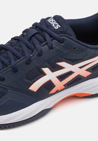 Námořnická sportovní obuv s síťovanými panely, bílými a oranžovými detaily, zaoblenou špičkou a texturovanou gumovou podrážkou. Logo ASICS na jazyku.