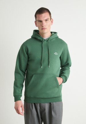 Felpa verde con cappuccio realizzata in morbido tessuto, dotata di cordino, tasca frontale, orlo a costine e piccolo logo bianco sul petto.
