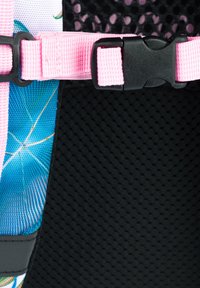 Pozadí tvoří modro-růžová vzorovaná látka; černá texturovaná část se růžovým popruhem a černou sponou.