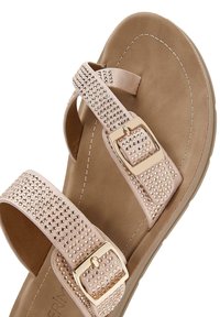 Lichtroze sandalen met twee brede banden versierd met rhinestones en een gouden gesp. Zachte, geweven voetbed met een iets verhoogde zool.