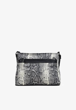 Bolso bandolera de estampado de serpiente en blanco y negro con textura suave, bolsillo frontal con cremallera y correa ajustable. Detalles en negro en la ferretería.