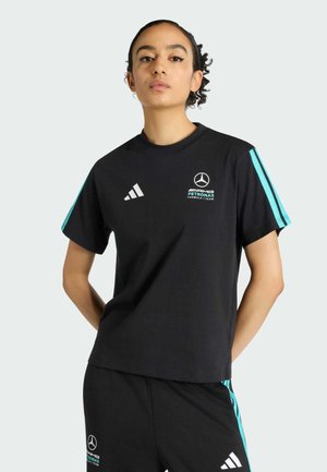 Schwarzes sportliches T-Shirt mit kurzen Ärmeln. Verfügt über türkisfarbene Streifen an den Ärmeln sowie die Logos von Mercedes-Benz und AMG Petronas. Hergestellt aus weichem Baumwollmaterial.