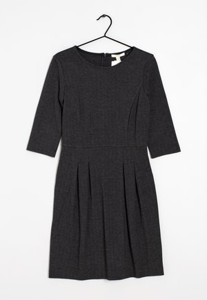 Graues Fischgratkleid mit Dreiviertelärmel, tailliertem Oberteil und plissiertem Rock. Verfügt über einen runden Ausschnitt und einen Reißverschluss auf der Rückseite.