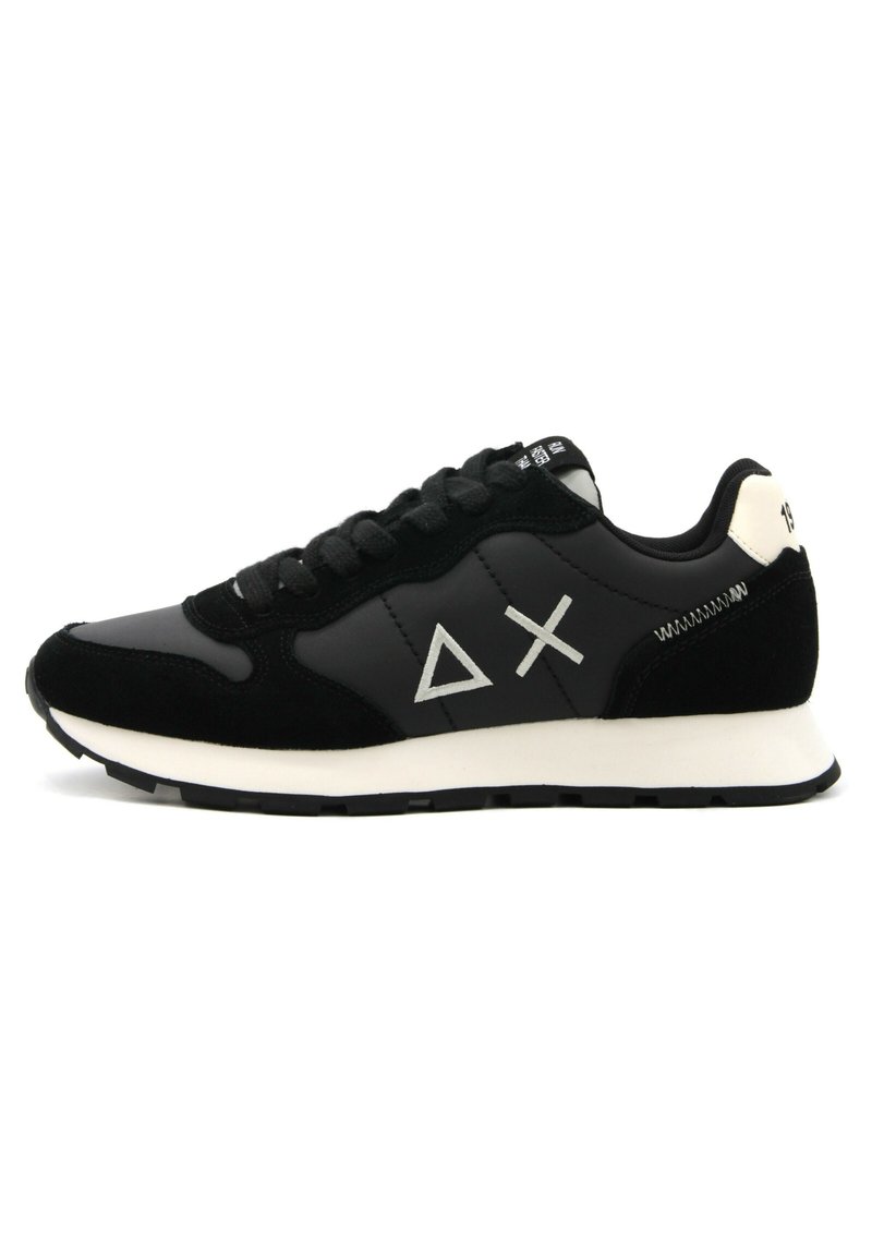 Sneaker nera con materiali in pelle e camoscio. Presenta dettagli bianchi e logo. Design con lacci, suola testurizzata e punta arrotondata.