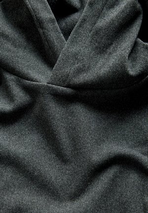 Dark gray hooded sweatshirt with a textured ribbed fabric, featuring a crossover neckline and soft, draped appearance.