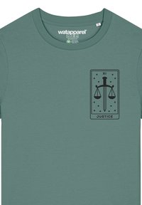 Teal katoenen t-shirt met een zwart grafisch ontwerp van een zwaard en schalen binnen een rechthoekig kader, met de tekst "JUSTITIE" onderaan.