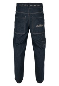 Dark denim cargo pants with tan stitching, multiple pockets, and a waistband featuring "PREMIUM URBAN BRAND" text. "SOUTHPOINT ORIGINALS" logo on back.