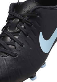 Czarne korki piłkarskie z teksturowanej skóry, czarnymi sznurowadłami i jasnoniebieskim logo Nike. Wyposażone w wiele kolców zapewniających przyczepność.