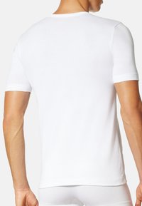 Maglietta bianca a maniche corte con collo rotondo, realizzata in tessuto morbido. Presenta un design slim fit e una texture liscia. Vista posteriore mostrata.